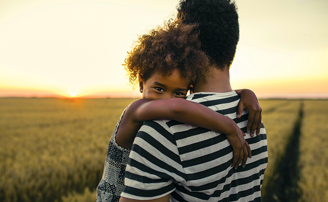 Man holding child at sunset