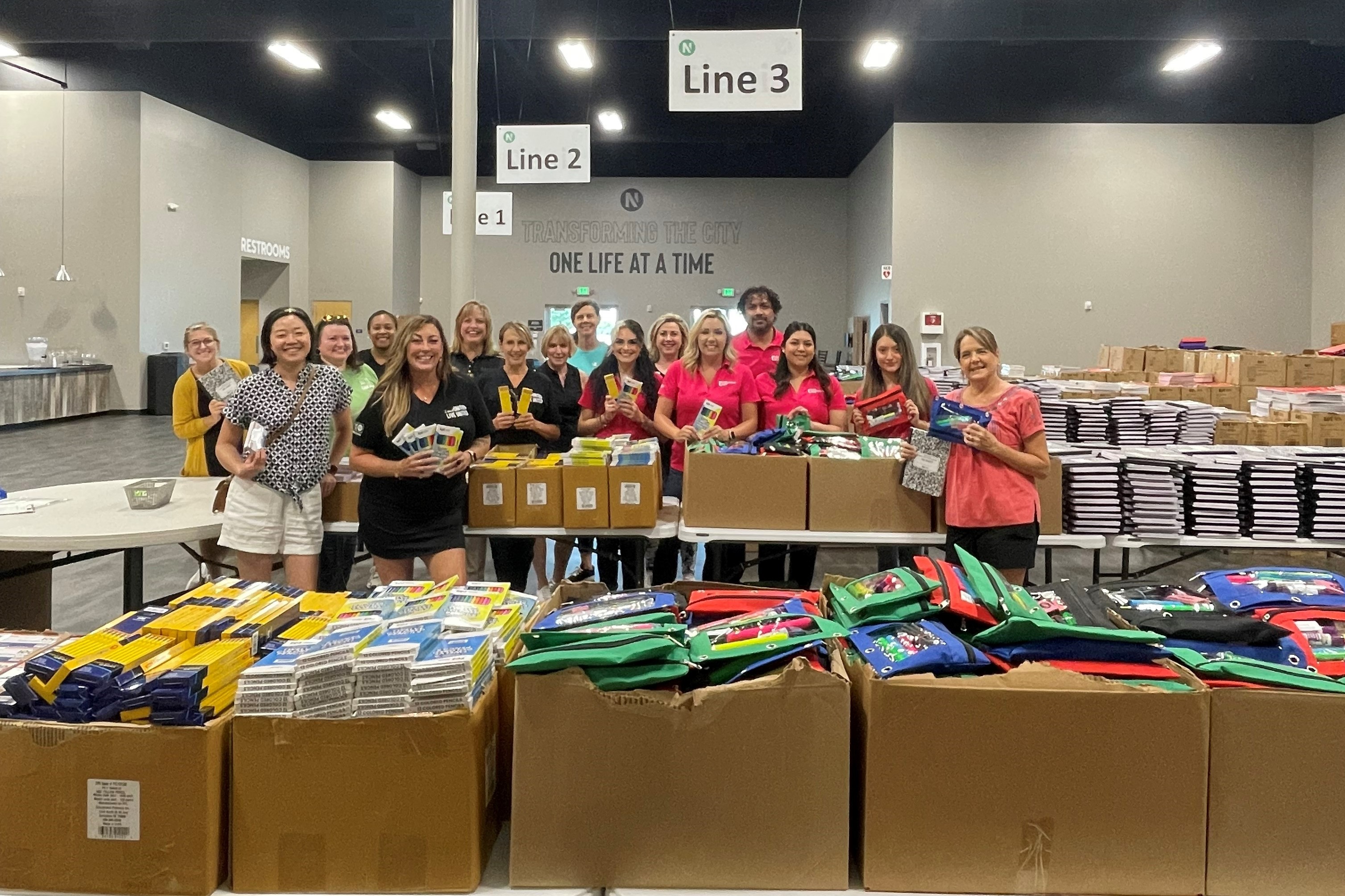 Women UNITED Members assembling backpacks for LISD