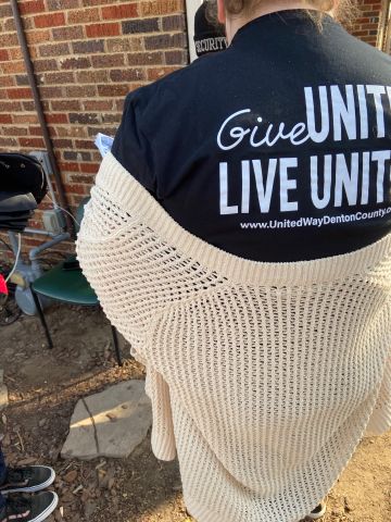 a UWDC intern, wearing a 'Give United, Live United shirt' surveying an individual not pictured