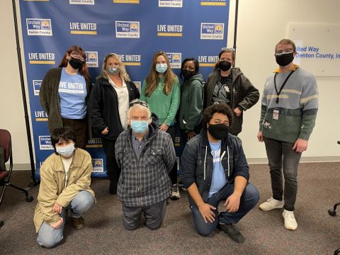 Several volunteers, wearing masks, at United Way of Denton County offices posing for photo