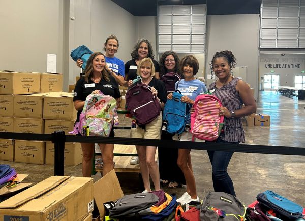 Women UNITED volunteers sorting backpacks